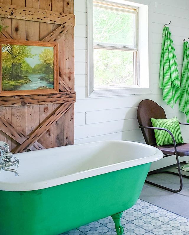 Modern rustic bathroom with green bathtub