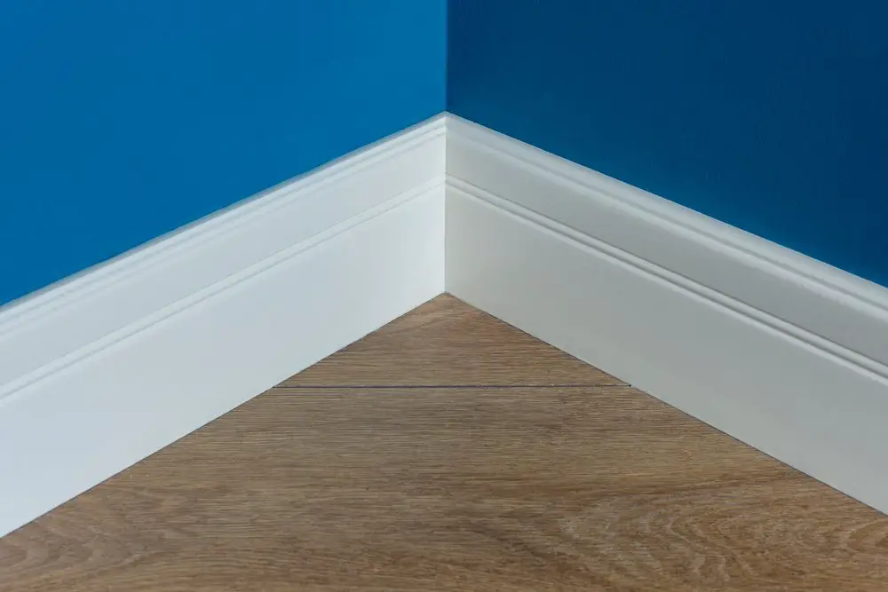 Moulding in the corner. Blue Matte Wall with laminate immitating oak texture